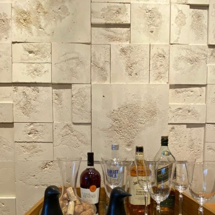 Superfície com revestimento travertino Verite em parede interna, destacando textura natural e tons neutros.